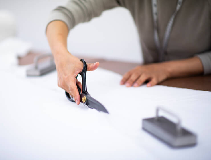 A women cutting fabric with scissors